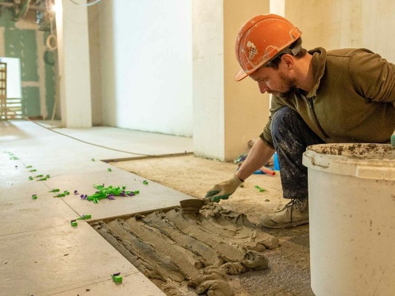 Albañil colocando solado porcelánico en una reforma