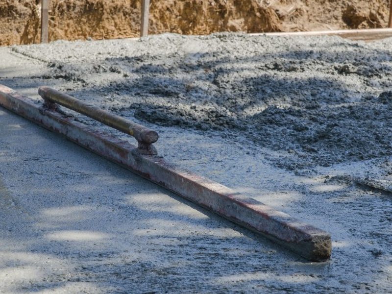 Mortero autonivelante extendido con regla sobre una solera