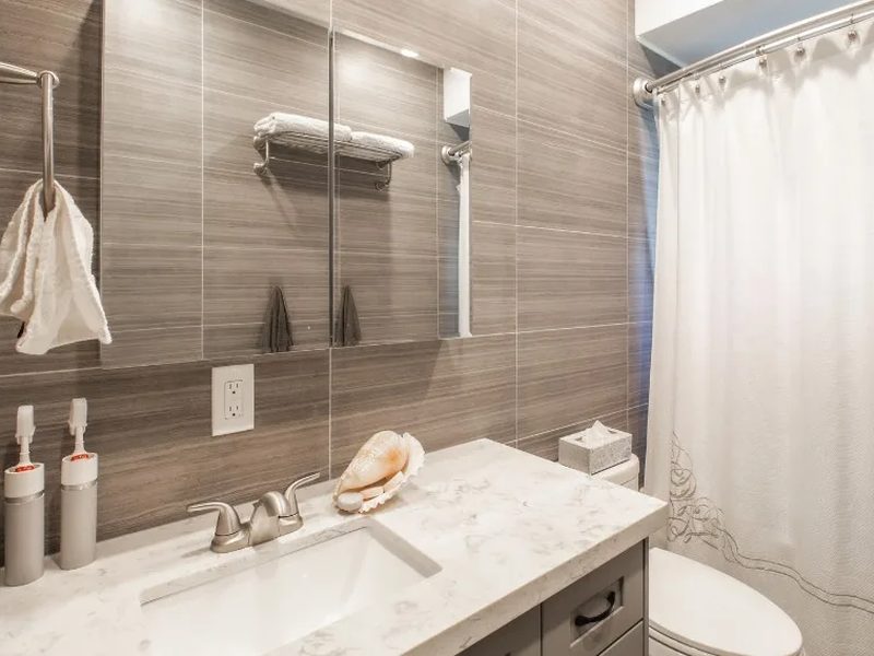 Baño reformado con lavabo de microcemento y revestimientos continuos sin juntas