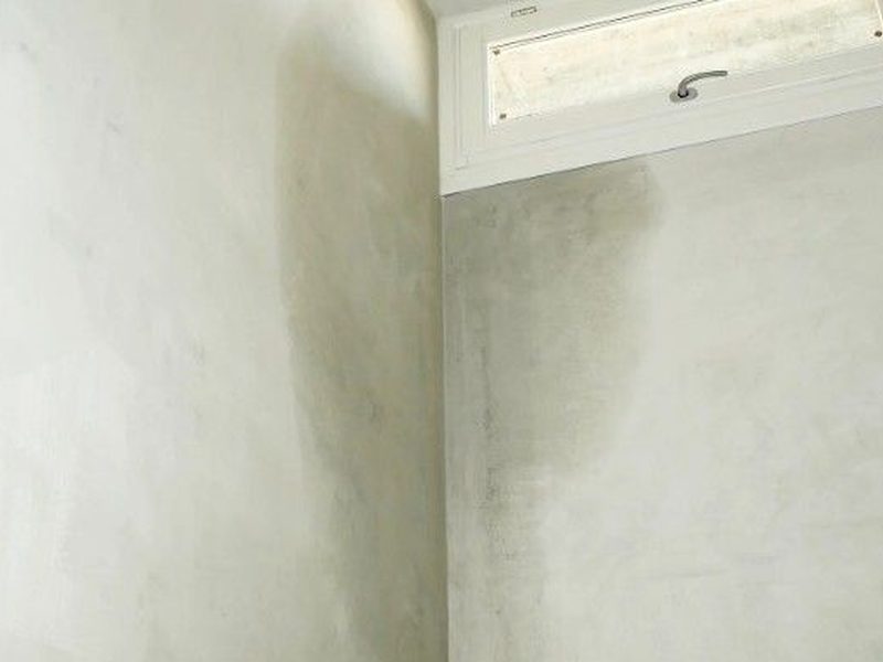Pared con manchas de humedad junto a una ventana