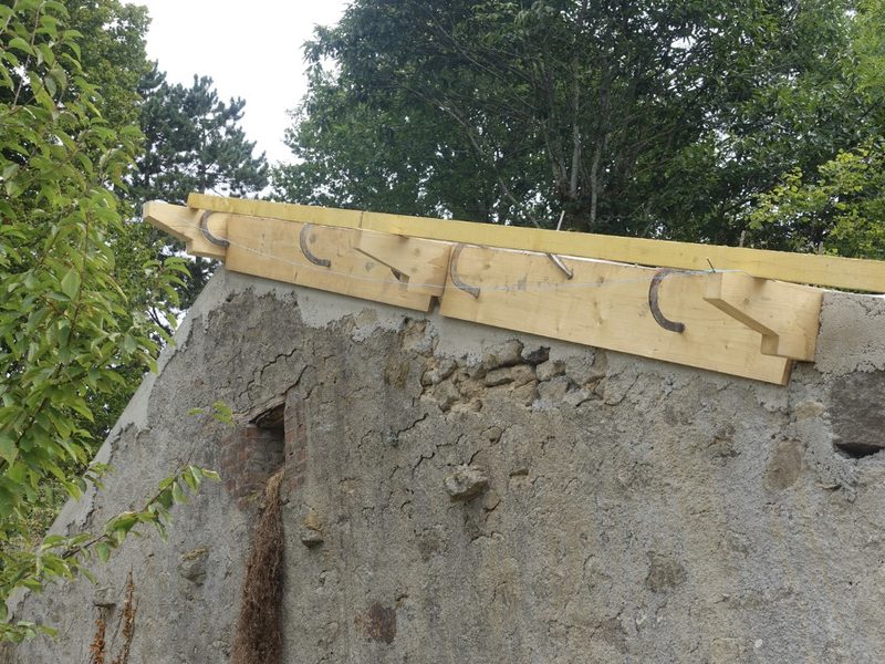 Casa de campo en rehabilitación con muro de piedra saneado y nueva estructura de madera para la cubierta