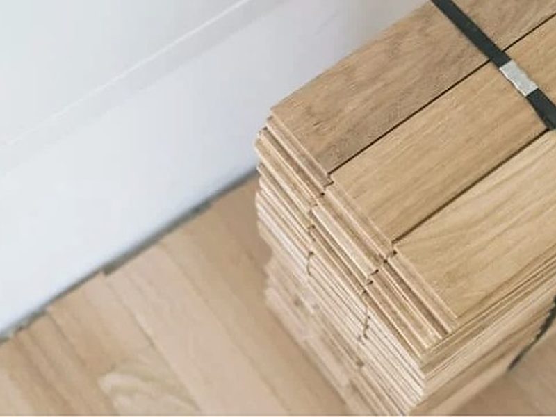 Lamas de tarima de roble apiladas en la vivienda antes de su colocación